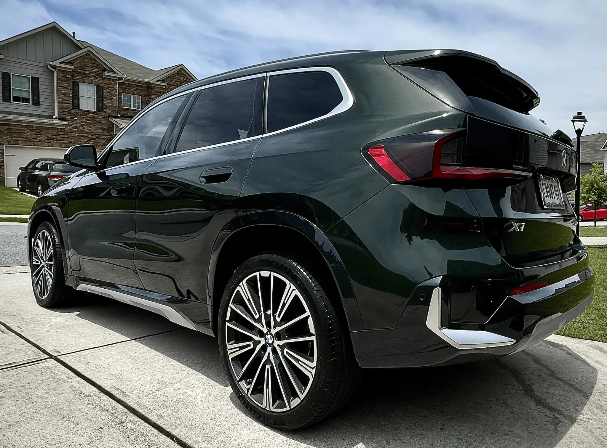 Sumptuous Mobile Detailing — dark green BMW X1 M-Sport SUV rear view after exterior detail in a suburban driveway